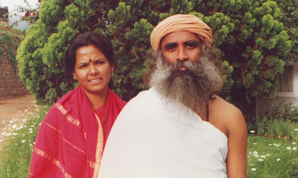 Vijji and Sadhguru with intense gaze and tree in the background.