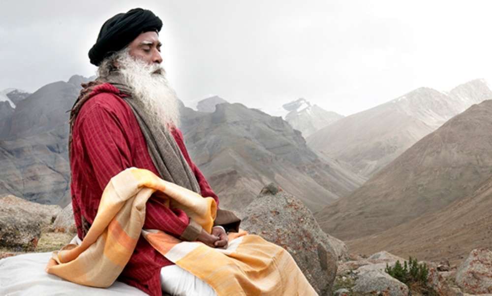 Role of a guru: Sadhguru sitting eyes closed near a moutain