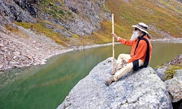 Sadhguru sitting on an outcrop of a rock at the Kantisarovar, Himalayas