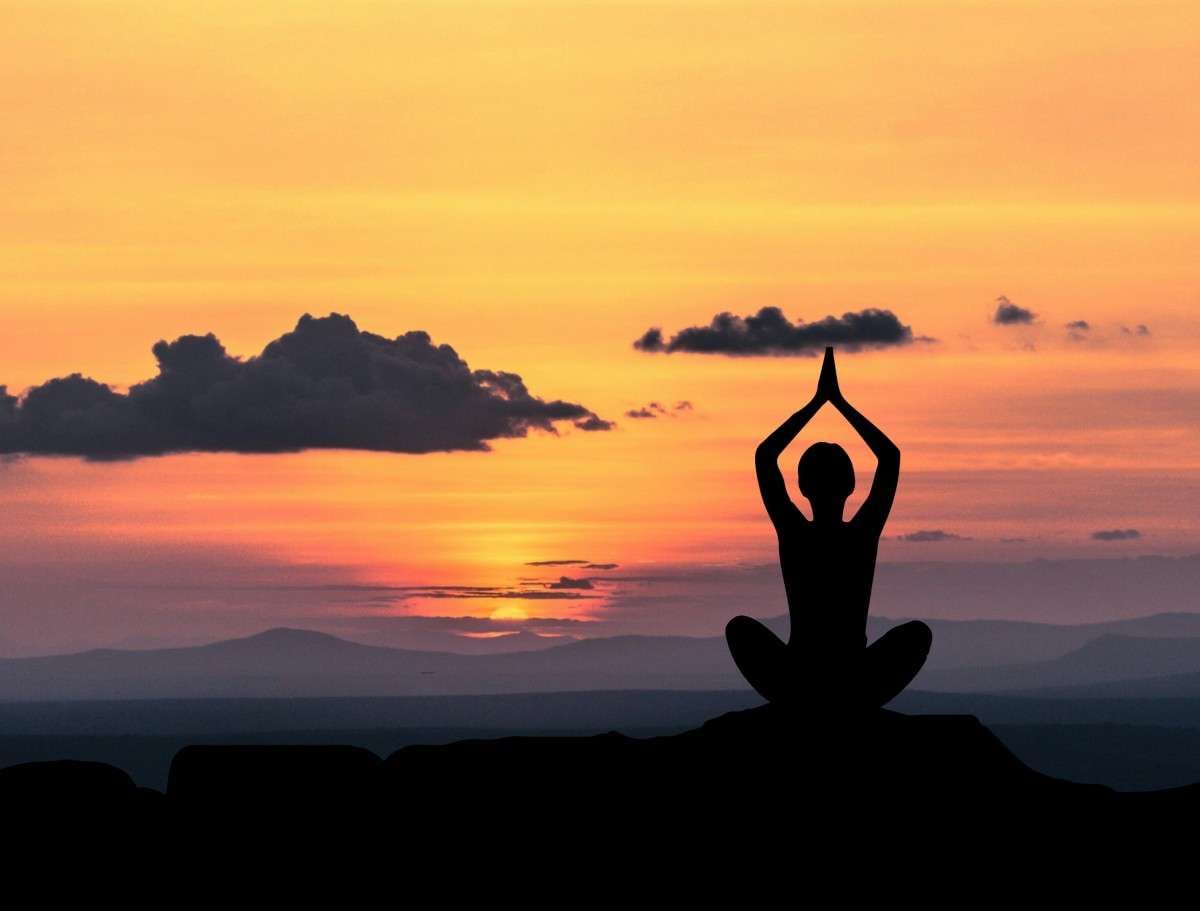 "Una mujer practicando Yoga y Meditacion al  amanecer "