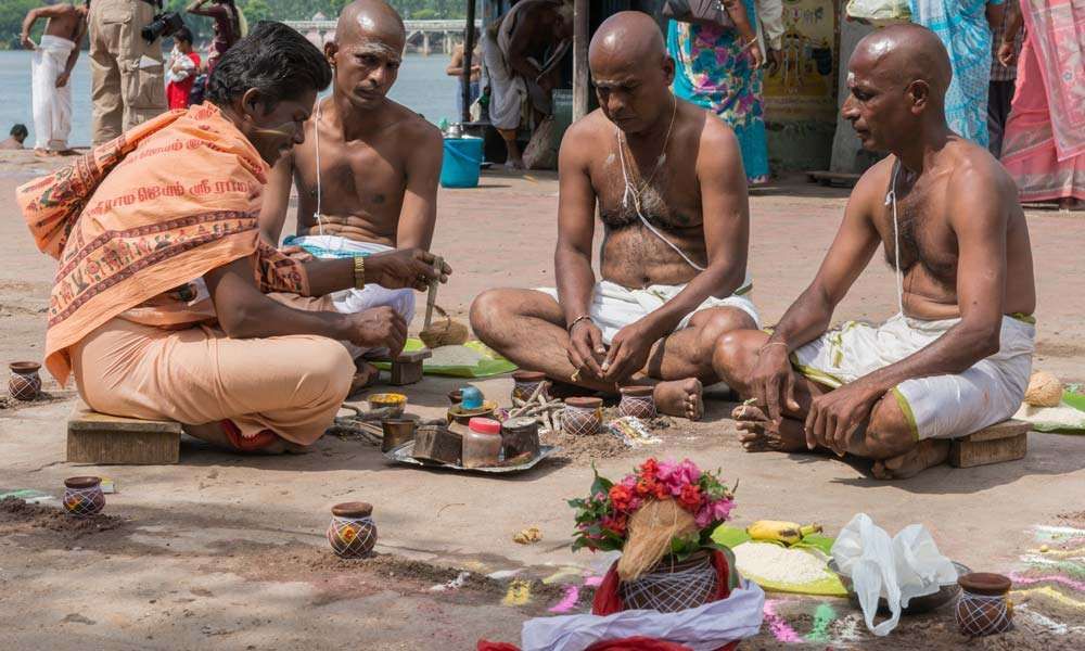 An Indian family participating in a traditional death ritual conducted by a priest