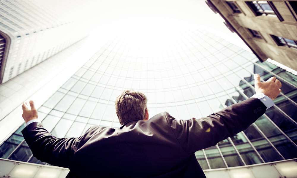 A Businessman looking up a skyscraper