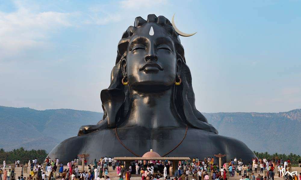 Shiva Adiyogi statue from the front with crowd of visitors.