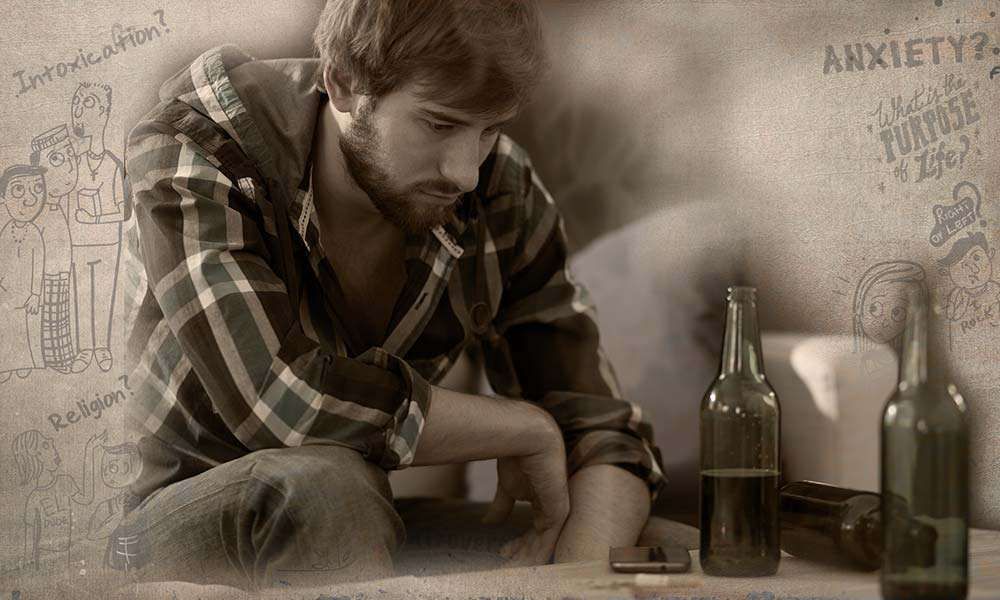 A depressed young man sitting on a couch with alcohol before him | Why Are Youth Turning to Alcohol and Drugs?