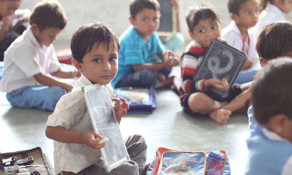 Children holding slate and chalk in school 
