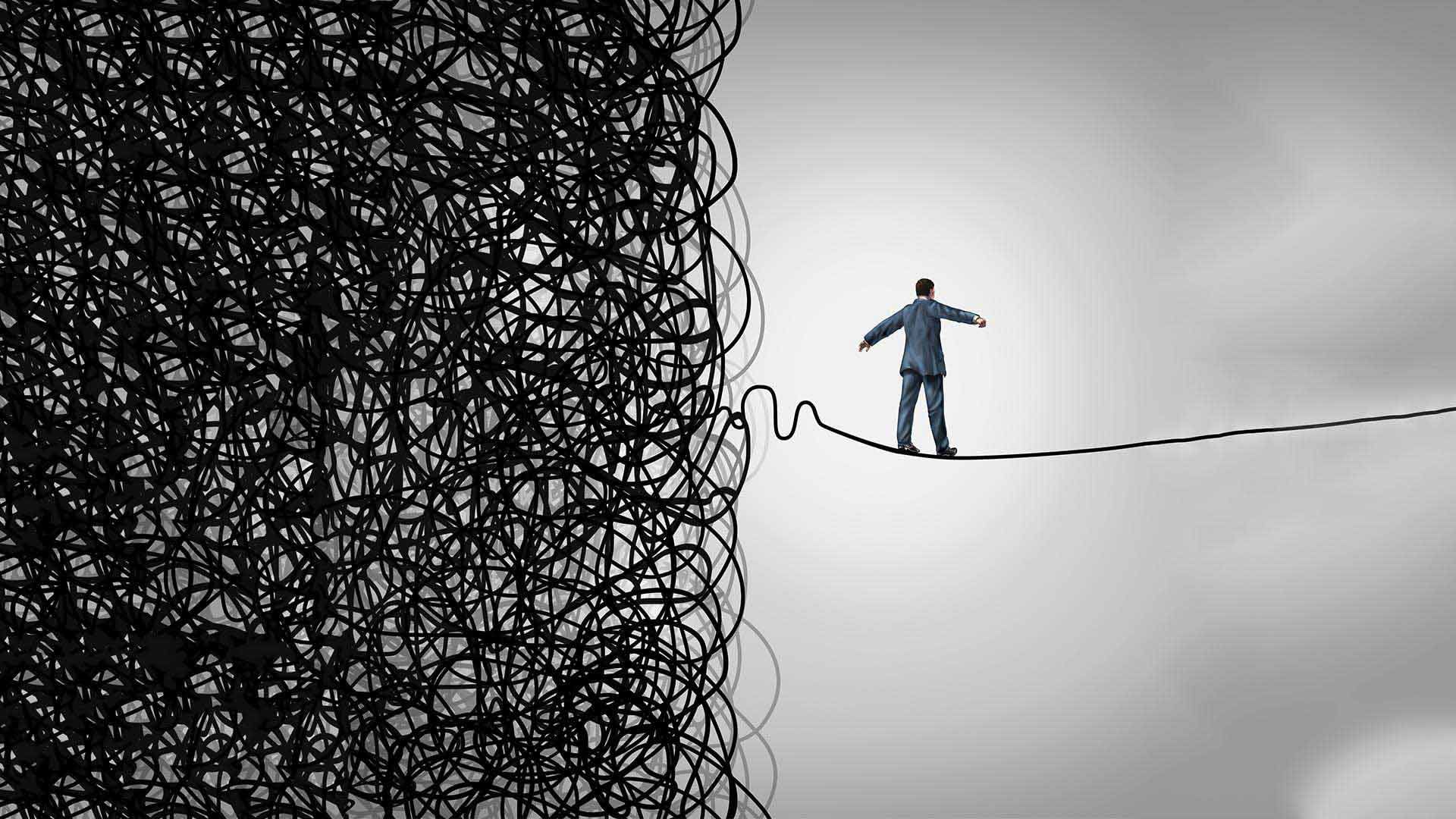 Image of a man balancing on a wire, having left the tangled mass of his past behind him.