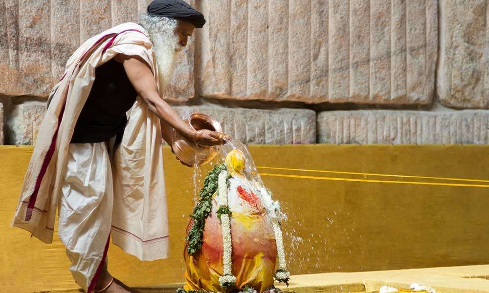 Sadhguru pouring water over a linga.