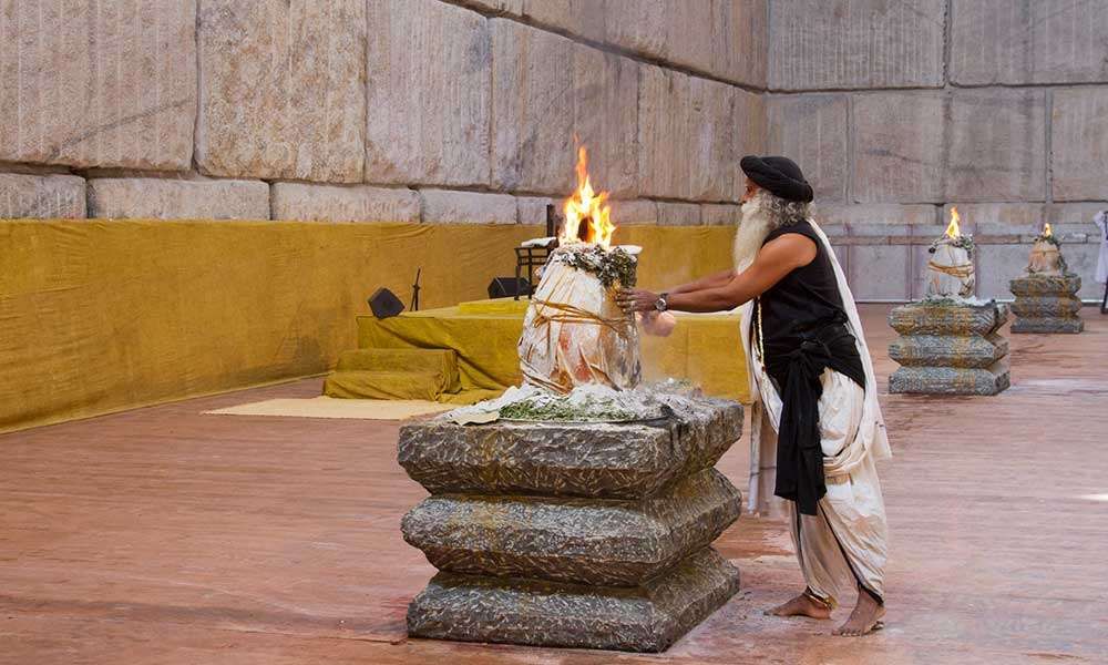 Sadhguru touching a linga which is on fire, at the Suryakund consecration.