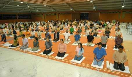 A group of people learning yoga at Isha Yoga Centers Spanda Hall near Coimbatore.