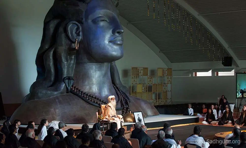 Sadhguru sitting near the picture of Sadhguru Sri Brahma
