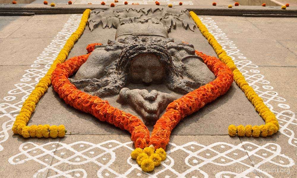 Inside Isha Dhyanalinga temple: Stone sculpture of Yogi prostrating on the ground.
