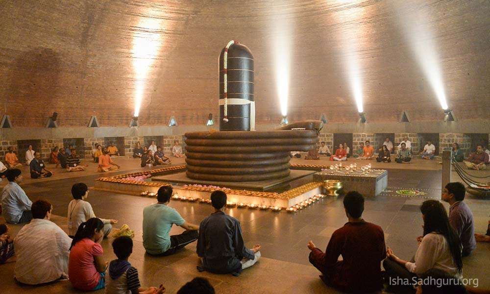 Crowd of people meditating inside dhyanalinga temple.