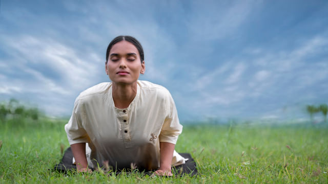 A meditator closing her eyes while doing an asana