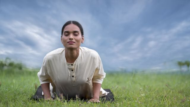 A meditator closing her eyes while doing an asana