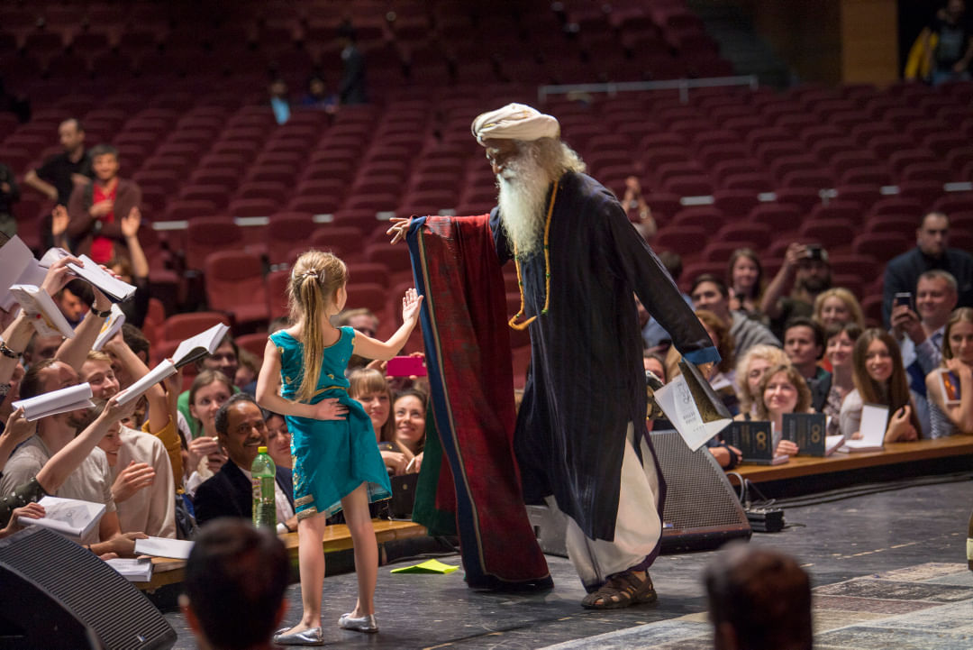 Sadhguru dances with a little girl at the conclusion of the "Wisdom, Meditation, Bliss," event, Russia, June 2018