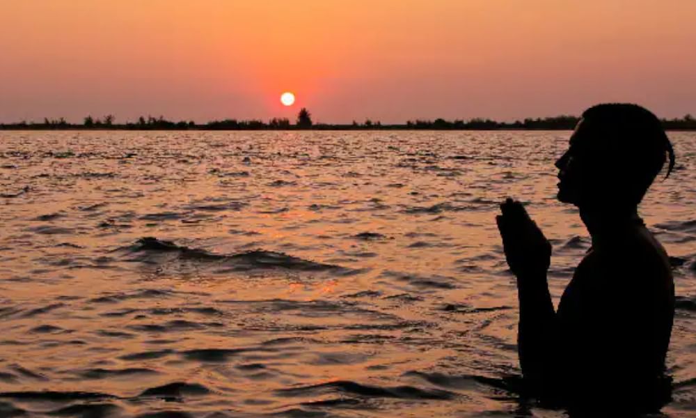 Picture of a Yogi doing namaskar by the river